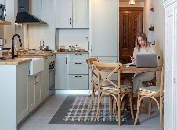 Lady Sitting in kitchen on laptop